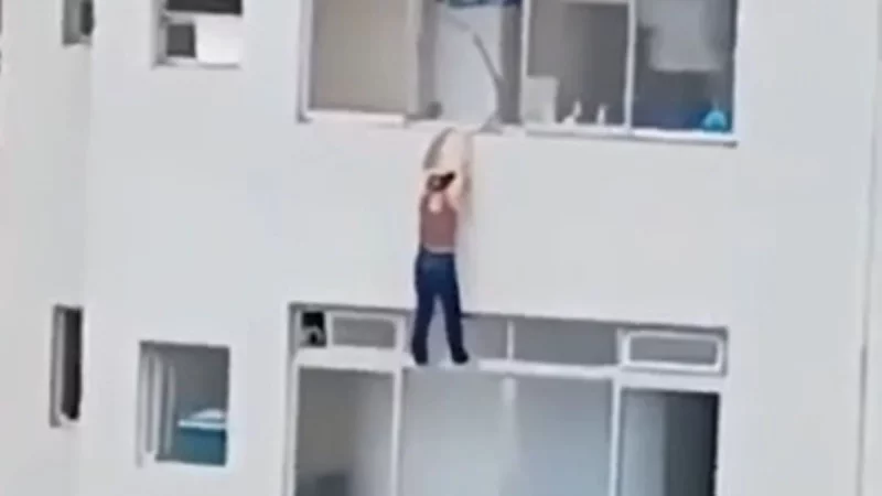 Mulher escorrega e fica pendurada na janela de prédio: assista ao vídeo!
